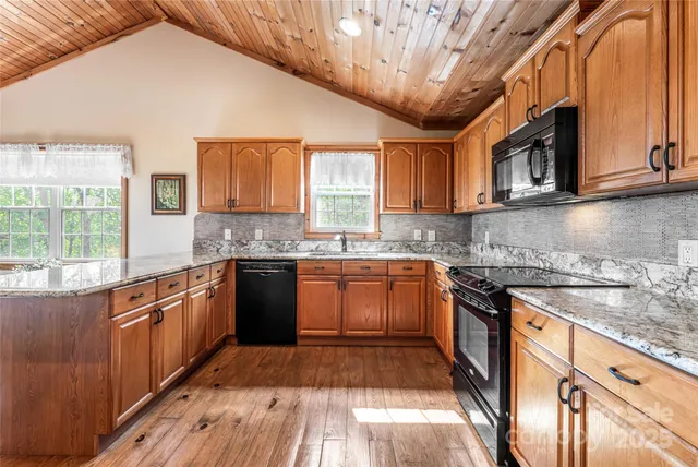 a kitchen with stainless steel appliances granite countertop a sink and wooden cabinets