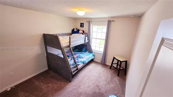 a living room with furniture and a baby crib