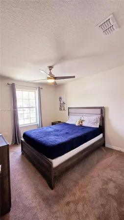 a spacious bedroom with a bed and window