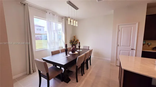 a view of a dining room with a table and chairs