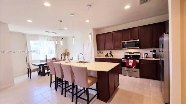 a kitchen with appliances a sink counter space and dining table