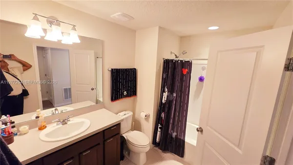 a bathroom with a sink vanity mirror and toilet
