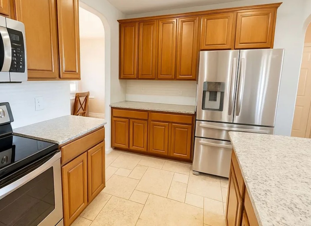a kitchen with a refrigerator sink and cabinets