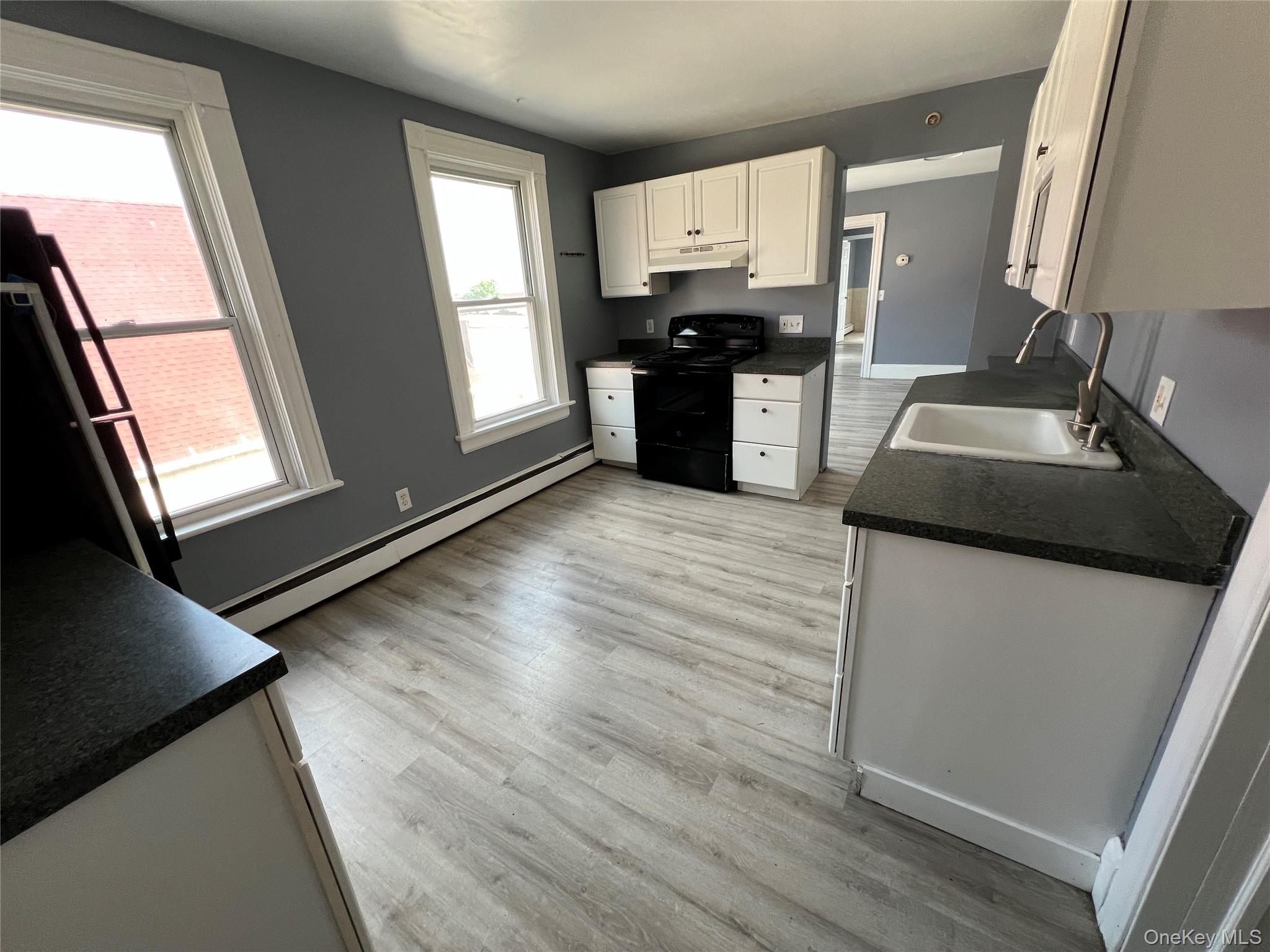761 Main Street, Unit 3E Poughkeepsie, NY 12603 - Photo 4 of 8 a kitchen with stainless steel appliances granite countertop a stove a sink and a refrigerator