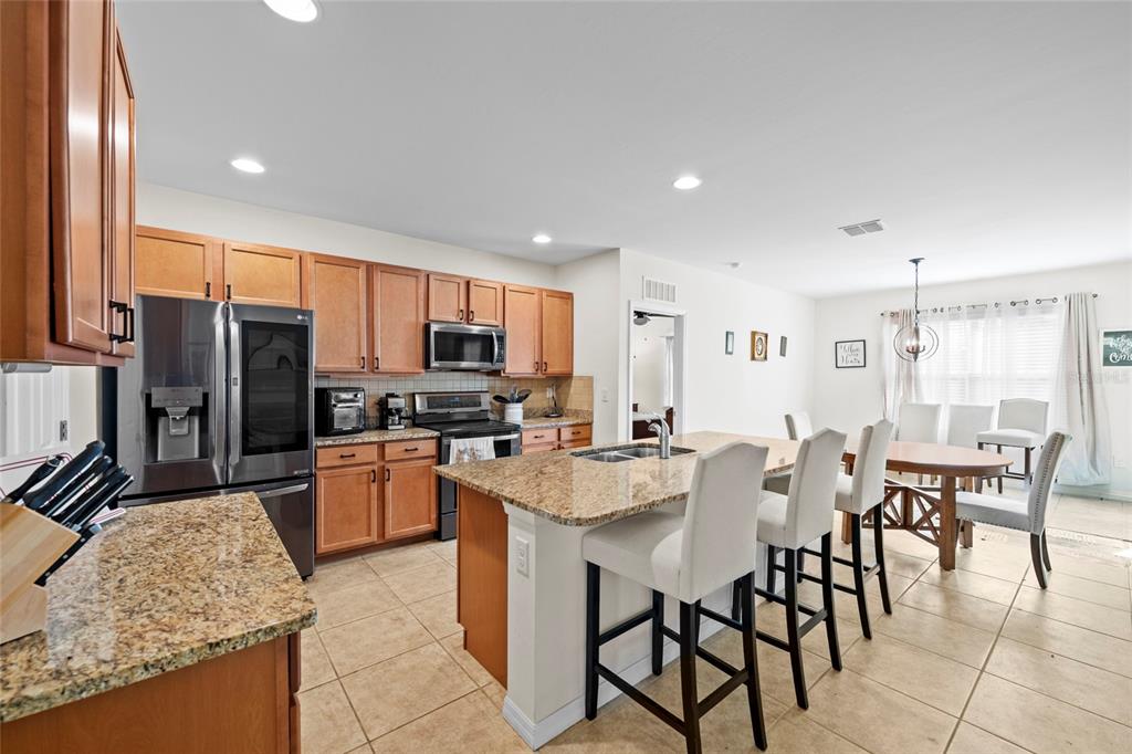 8921 Excelsior Loop Venice, FL 34293 - Photo 3 of 26 a large kitchen with kitchen island granite countertop a counter top space appliances and a center island