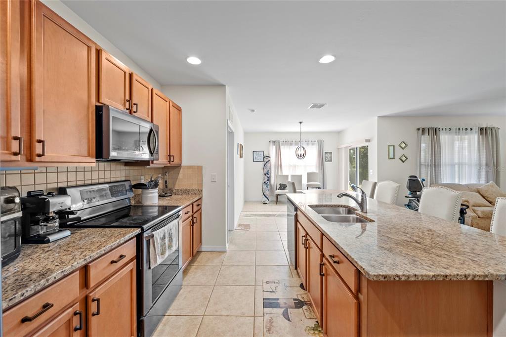 8921 Excelsior Loop Venice, FL 34293 - Photo 4 of 26 a kitchen with stainless steel appliances granite countertop a sink stove and cabinets