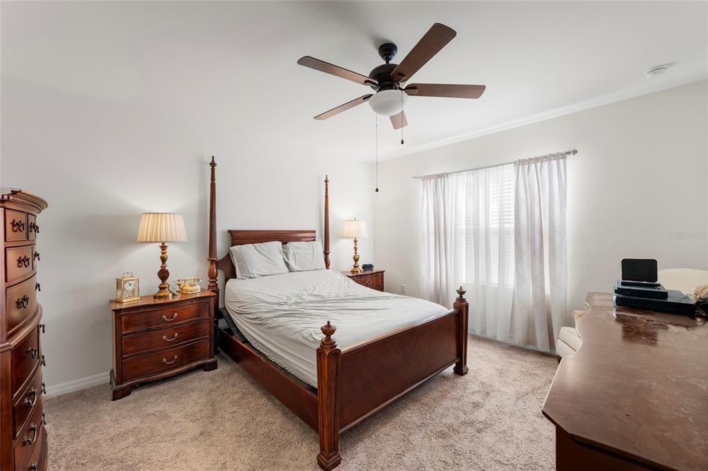8921 Excelsior Loop Venice, FL 34293 - Photo 10 of 26 a bedroom with a bed a ceiling fan and a dresser