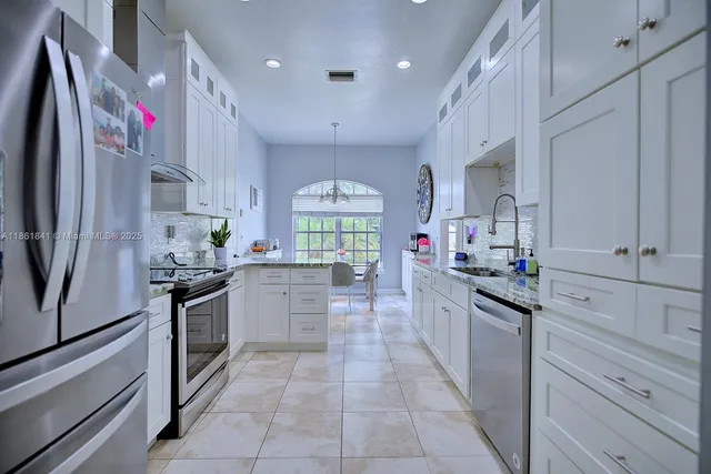 a kitchen with granite countertop stainless steel appliances and sink
