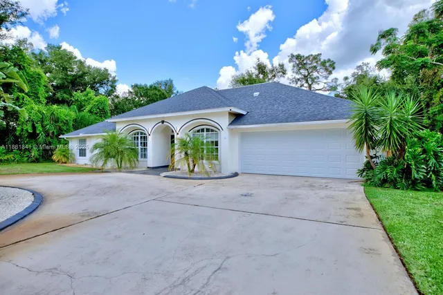 a aerial view of a house with a yard and potted plants