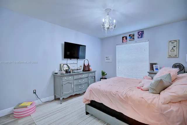 a bedroom with a large bed and a chandelier