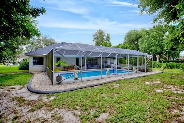 a view of a house with backyard and sitting area