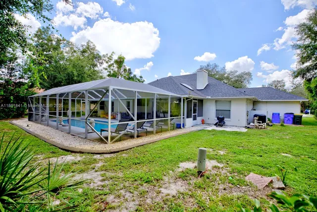 an aerial view of a house with yard and patio