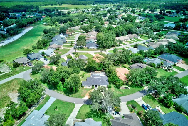 an aerial view of a houses with a yard and street