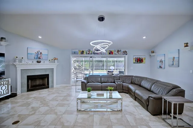 a living room with furniture a fireplace and a floor to ceiling window