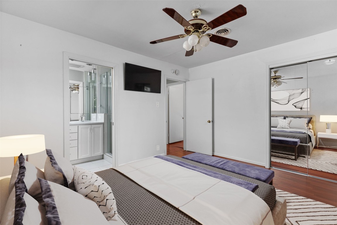 1105 Alegria Road Austin, TX 78757 - Photo 14 of 30 a bedroom with a large bed and a chandelier