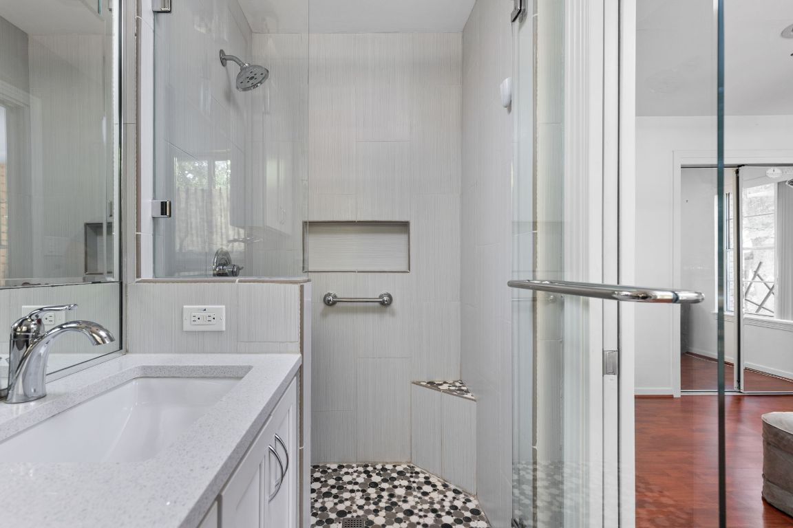 1105 Alegria Road Austin, TX 78757 - Photo 17 of 30 a bathroom with a granite countertop sink a mirror and shower
