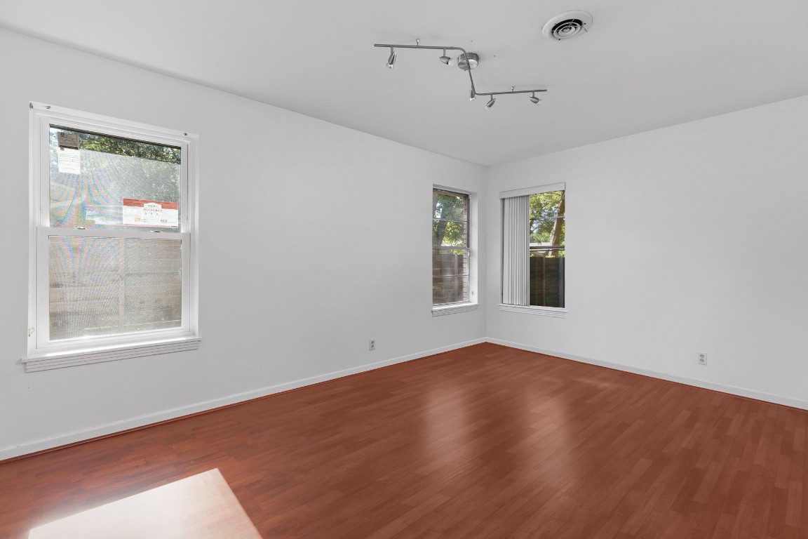 1105 Alegria Road Austin, TX 78757 - Photo 19 of 30 a view of an empty room with a window and wooden floor