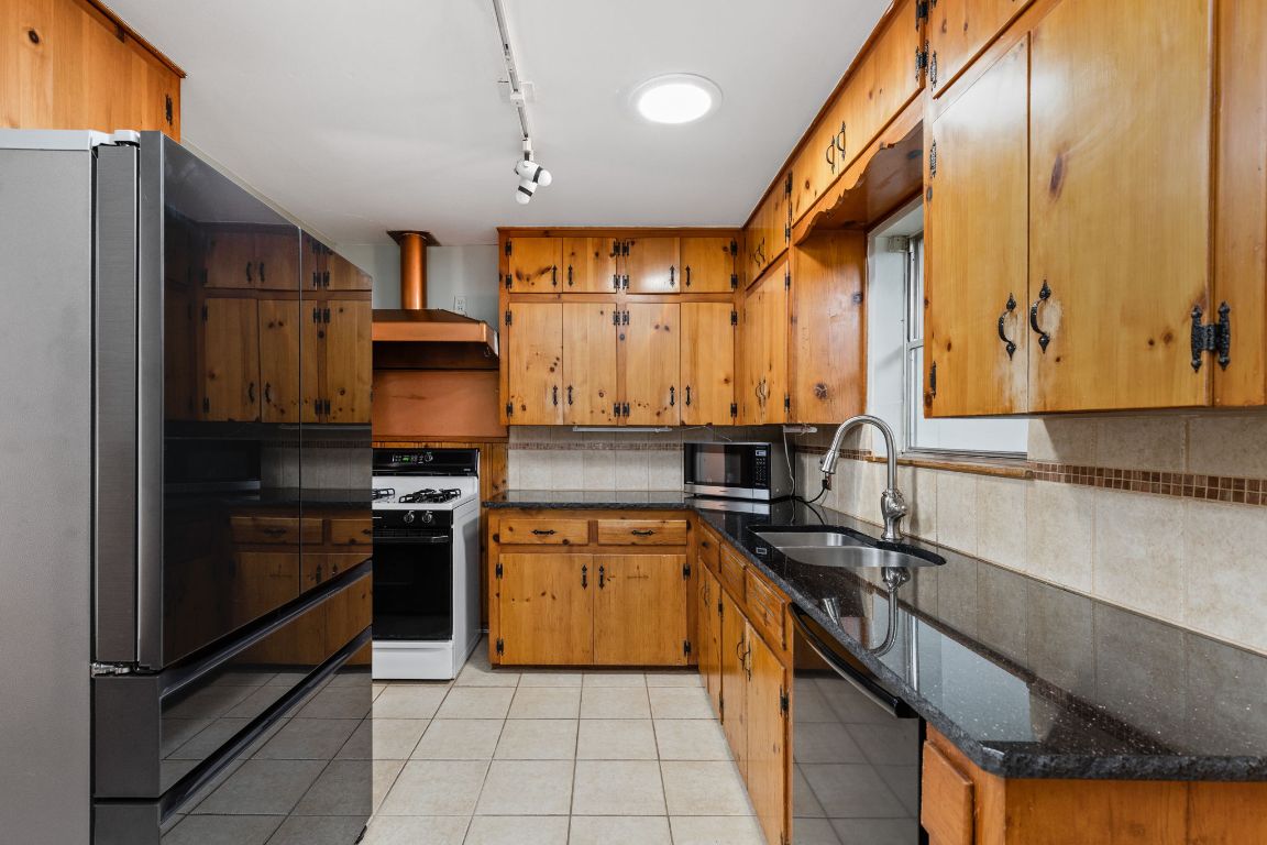 1105 Alegria Road Austin, TX 78757 - Photo 7 of 30 a kitchen with stainless steel appliances granite countertop a sink stove and refrigerator