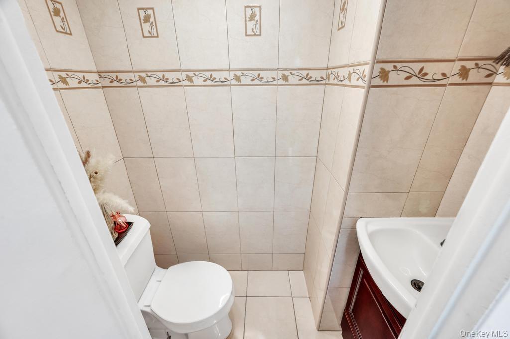89-13 84th Street Queens, NY 11421 - Photo 33 of 34 Ceramic tile walls featuring decorative accent bands and framed motifs