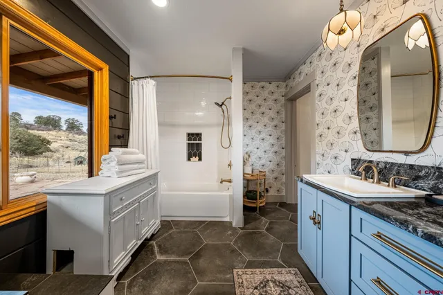 a bathroom with a double vanity sink mirror and bathtub