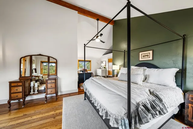 a bedroom with bed and wooden floor