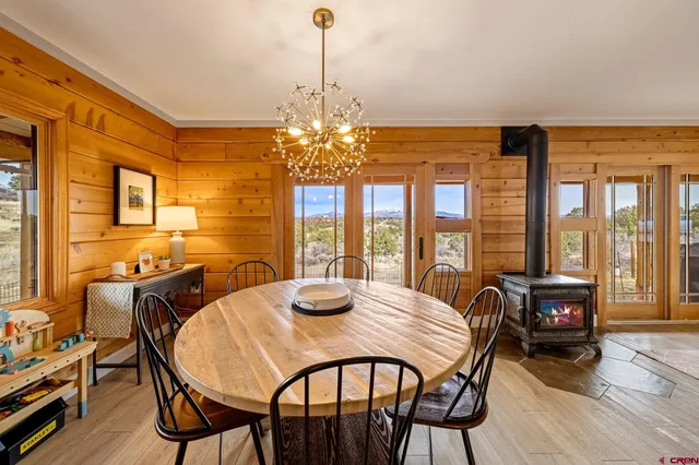 a view of a dining room with furniture large windows and wooden floor
