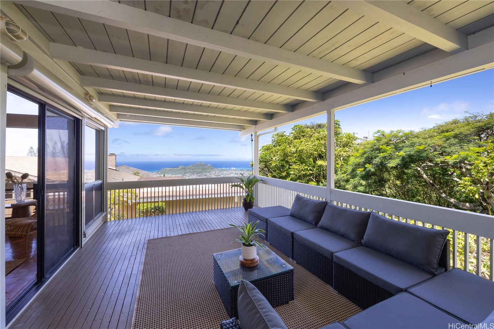 a balcony with furniture and a wooden floor