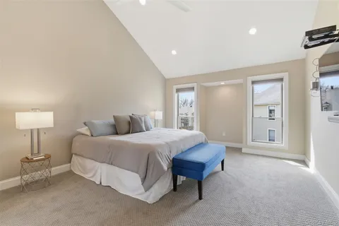 a spacious bedroom with a bed and a lamp