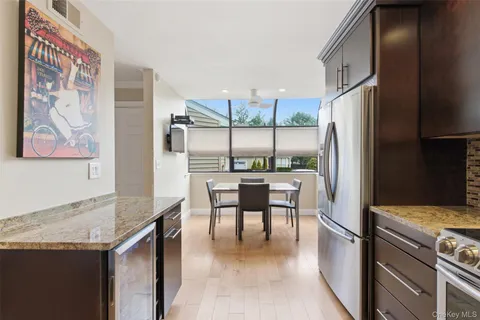 a kitchen with granite countertop a refrigerator a stove a sink and a refrigerator