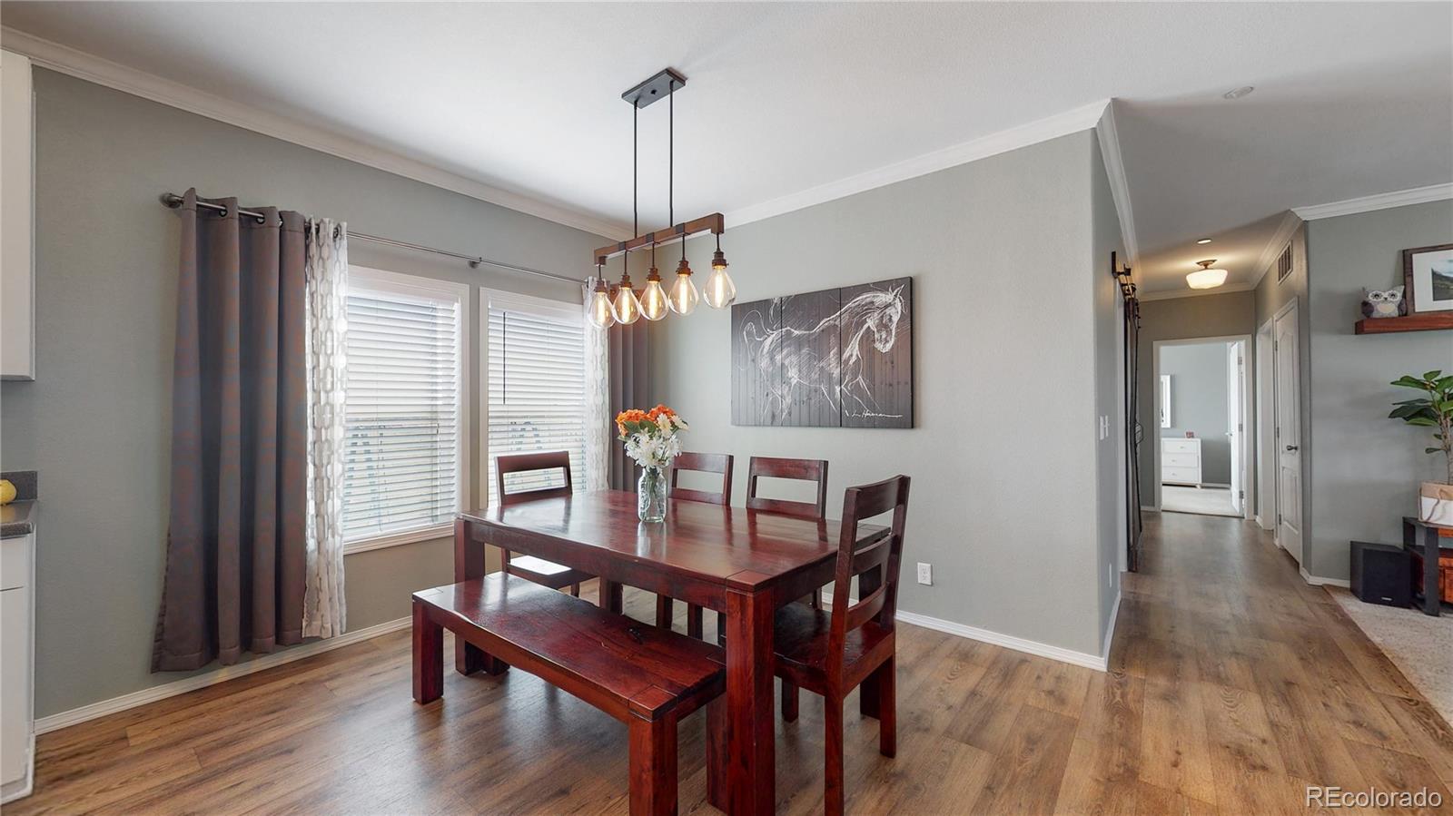 4038 Meadowlark Road Fort Lupton, CO 80621 - Photo 15 of 40 a view of a dining room with furniture window and wooden floor