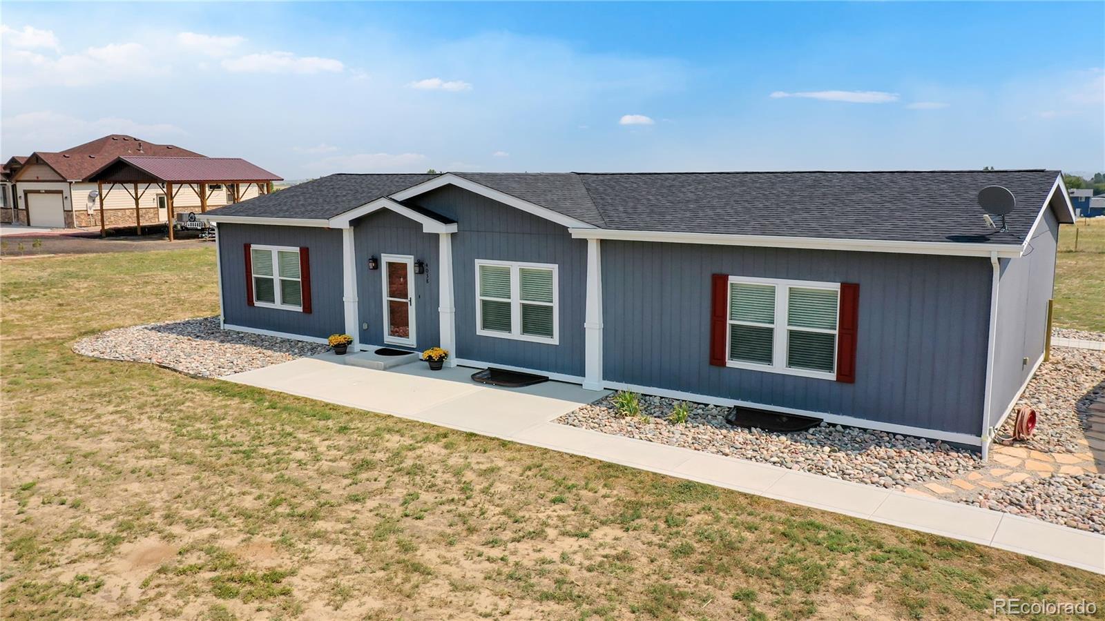 4038 Meadowlark Road Fort Lupton, CO 80621 - Photo 2 of 40 a front view of a house with a yard and garage