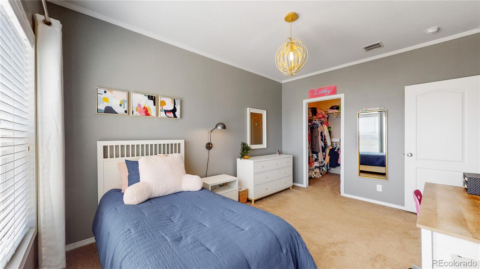 4038 Meadowlark Road Fort Lupton, CO 80621 - Photo 21 of 40 a bedroom with furniture and a chandelier