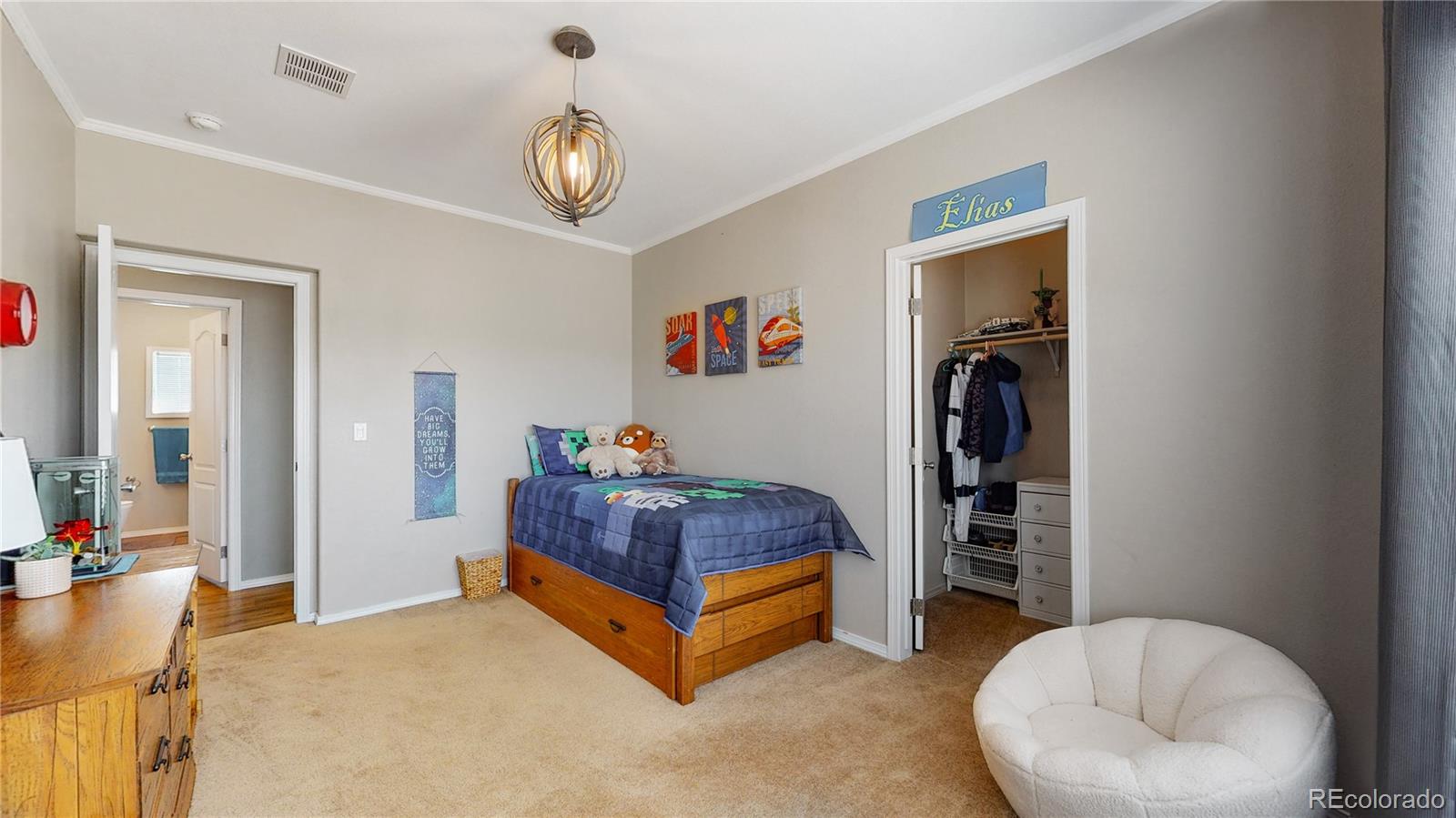 4038 Meadowlark Road Fort Lupton, CO 80621 - Photo 23 of 40 a bedroom with a bed and a chandelier