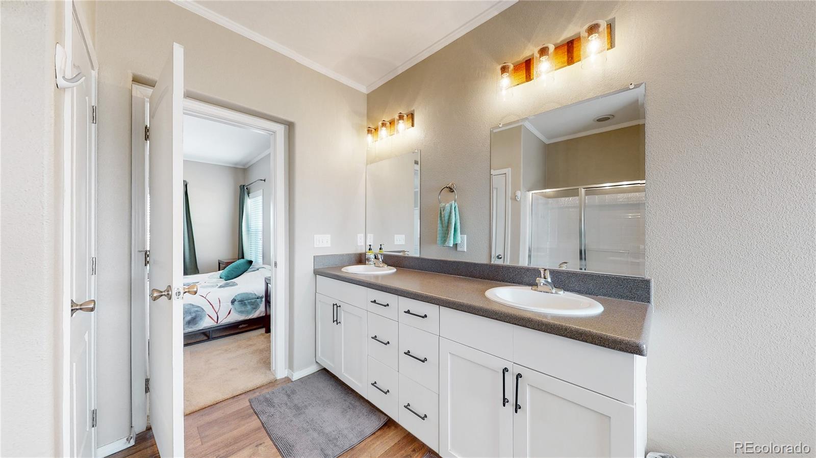 4038 Meadowlark Road Fort Lupton, CO 80621 - Photo 30 of 40 a en suite bathroom with a granite countertop sink and a mirror