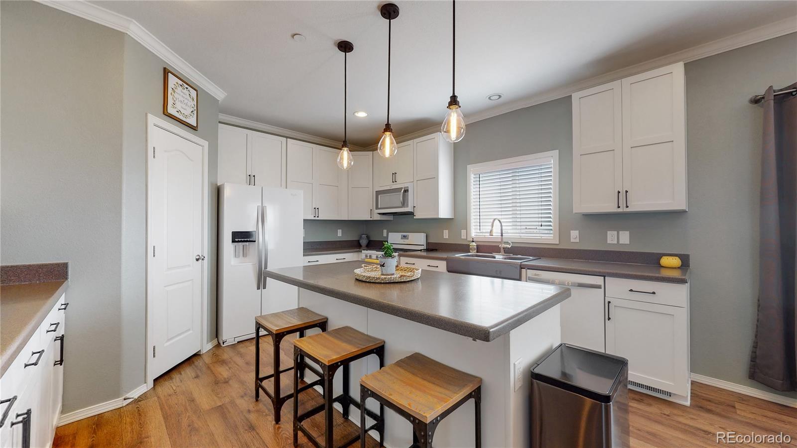 4038 Meadowlark Road Fort Lupton, CO 80621 - Photo 4 of 40 a kitchen with stainless steel appliances granite countertop a sink a stove a refrigerator and island