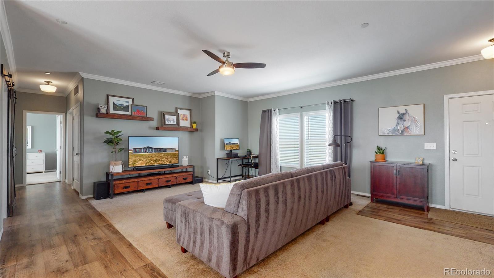 4038 Meadowlark Road Fort Lupton, CO 80621 - Photo 10 of 40 a living room with furniture and a flat screen tv