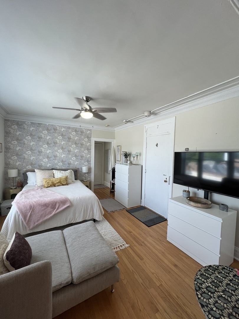 918 Green Bay Road, Unit 3J Winnetka, IL 60093 - Photo 3 of 14 a bedroom with furniture and a flat screen tv