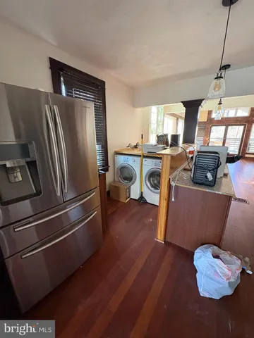 a kitchen with stainless steel appliances granite countertop a refrigerator a stove and a sink with wooden floor