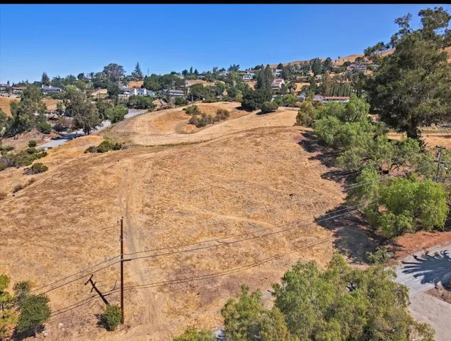 a view of a dry yard with trees