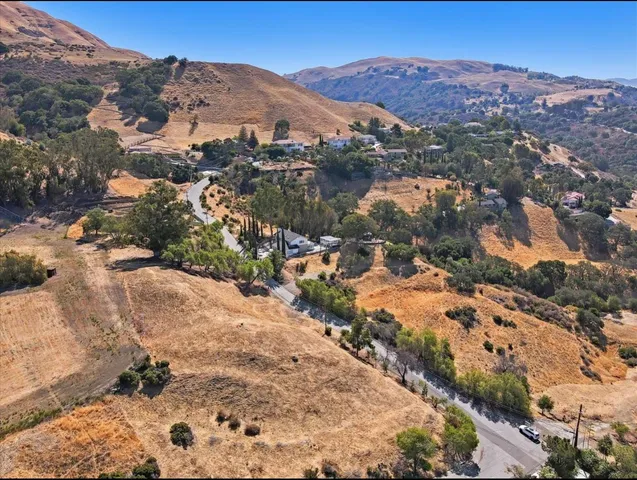 an aerial view of mountain with residential house and green space