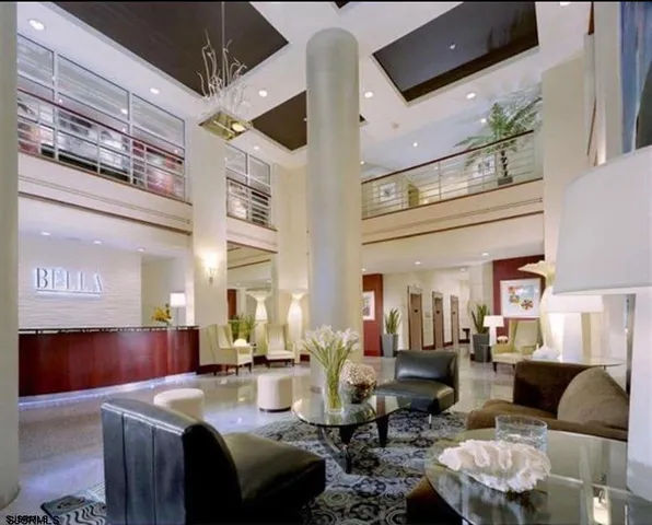 a large living room with lots of furniture and view of kitchen