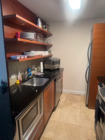 a kitchen with stainless steel appliances granite countertop a sink stove and cabinets