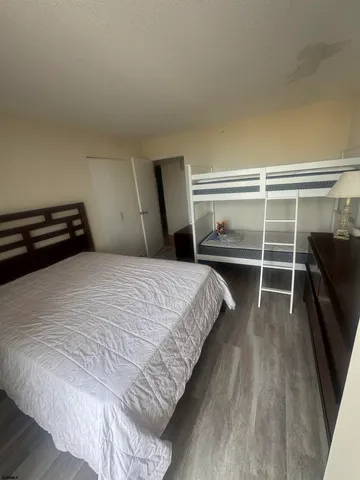 a bedroom with a bed and a flat tv screen on a dresser