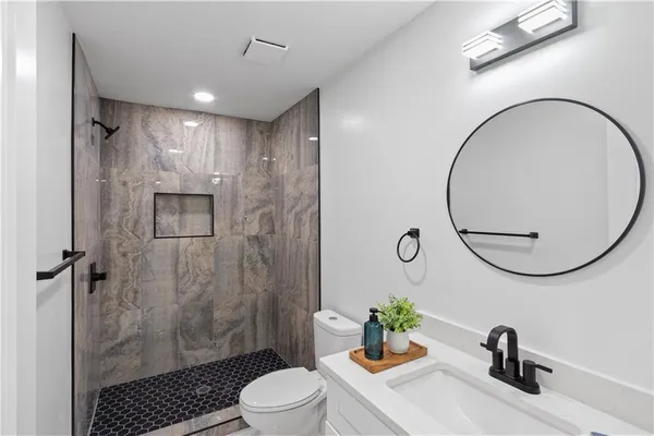 a bathroom with a sink a toilet and a mirror