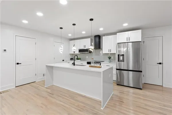 a kitchen with stainless steel appliances a refrigerator sink and microwave