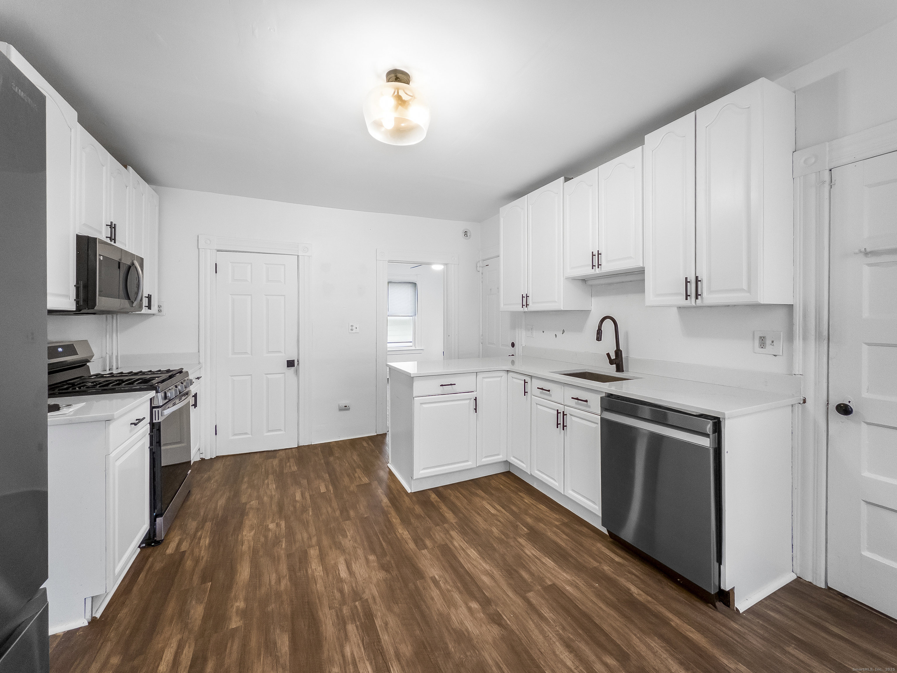634 High Street, Unit 1 Middletown, CT 06457 - Photo 8 of 16 a kitchen with wooden floors and white appliances
