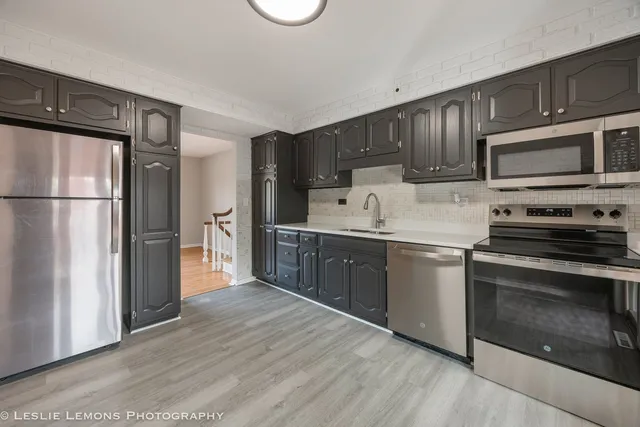 a kitchen with stainless steel appliances granite countertop a refrigerator stove and sink