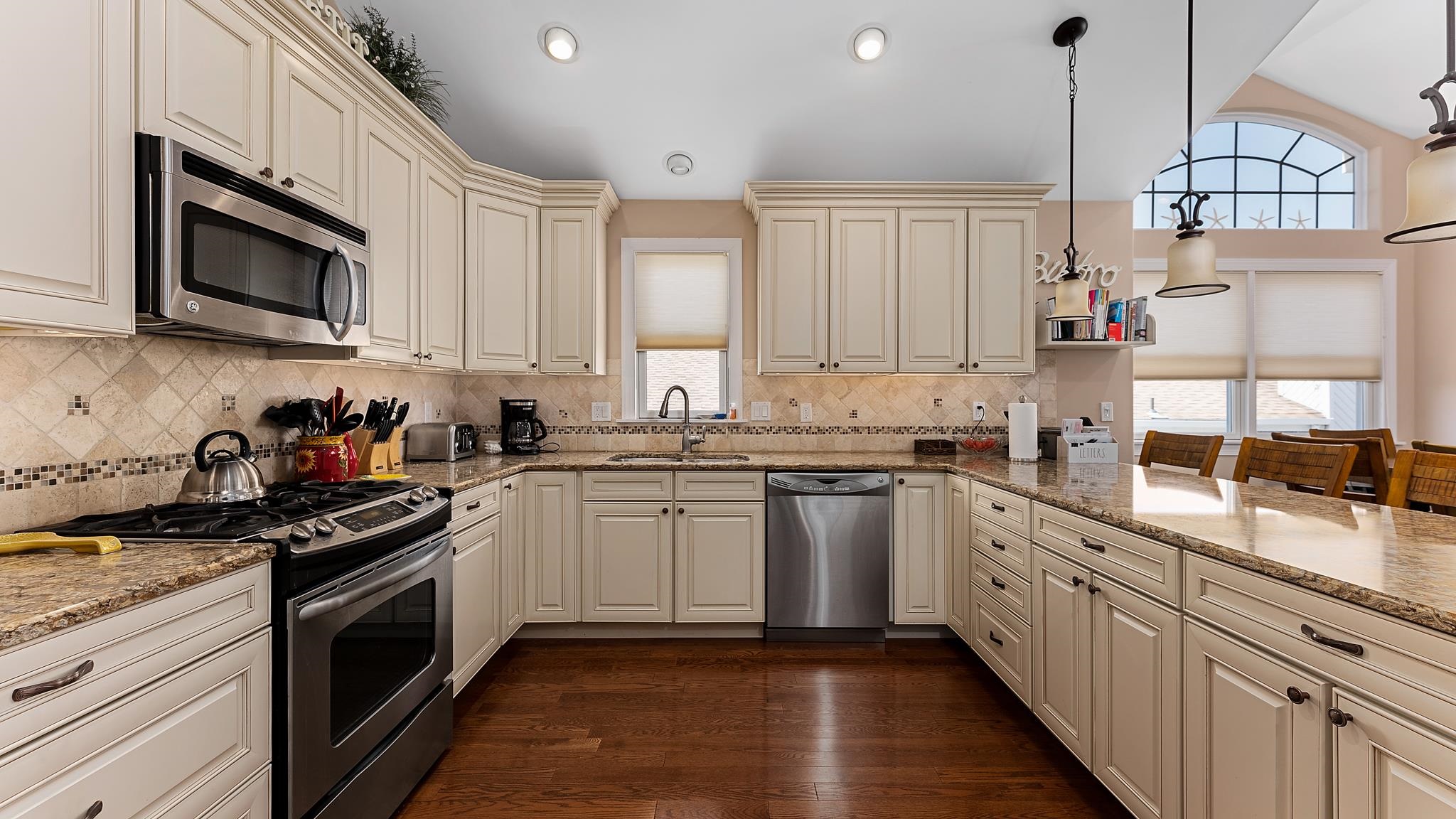 22 80th Street, Unit WEST Sea Isle City, NJ 08243 - Photo 11 of 32 a kitchen with stainless steel appliances granite countertop a stove a sink dishwasher and a microwave oven with white cabinets
