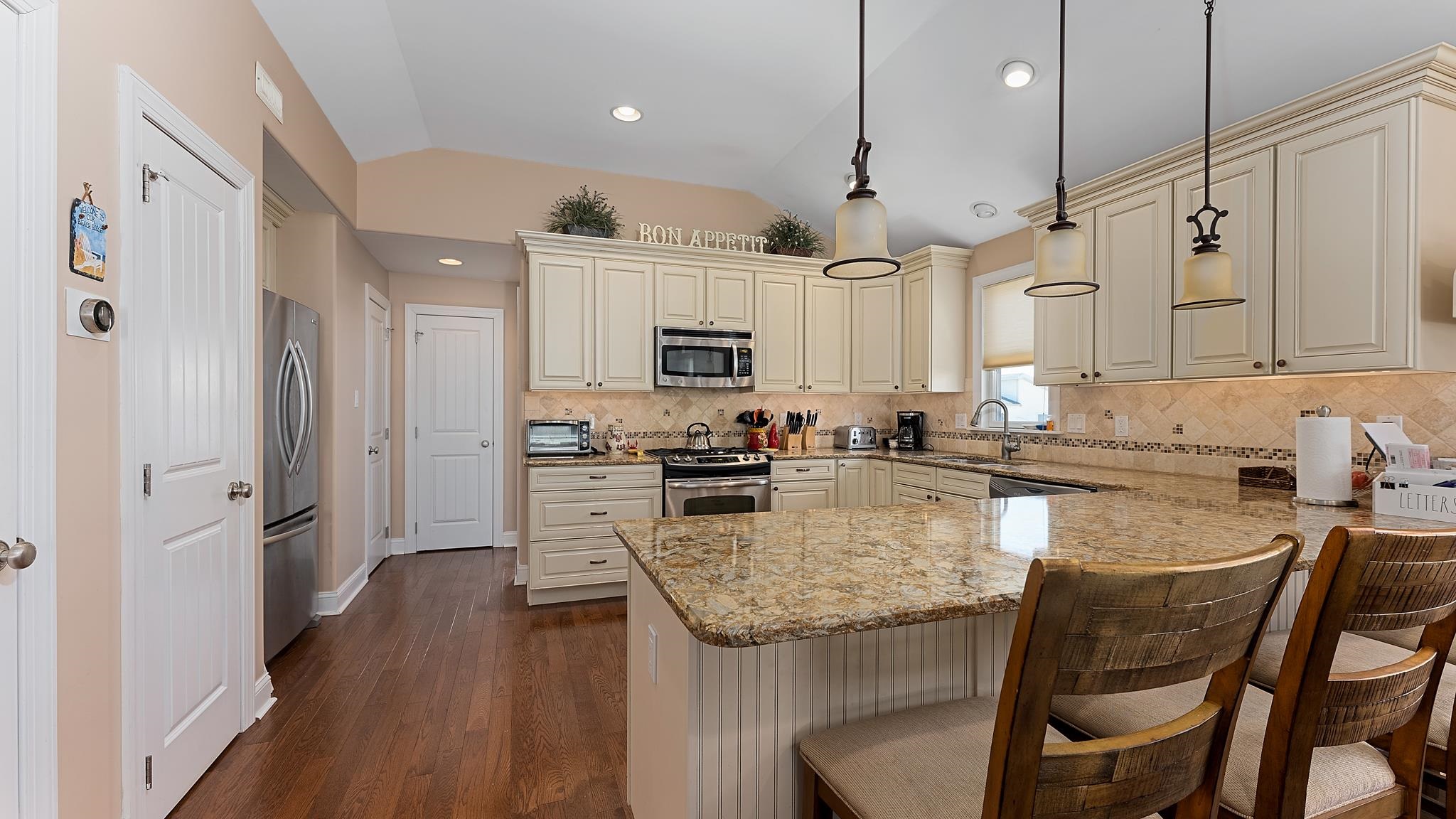 22 80th Street, Unit WEST Sea Isle City, NJ 08243 - Photo 10 of 32 a kitchen with stainless steel appliances granite countertop a stove refrigerator and a microwave oven with white cabinets