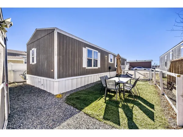 a backyard of a house with table and chairs